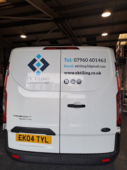 An image of the back of the white EK Tiling van with the new graphics displaying the number, email, and URL for EK Tiling